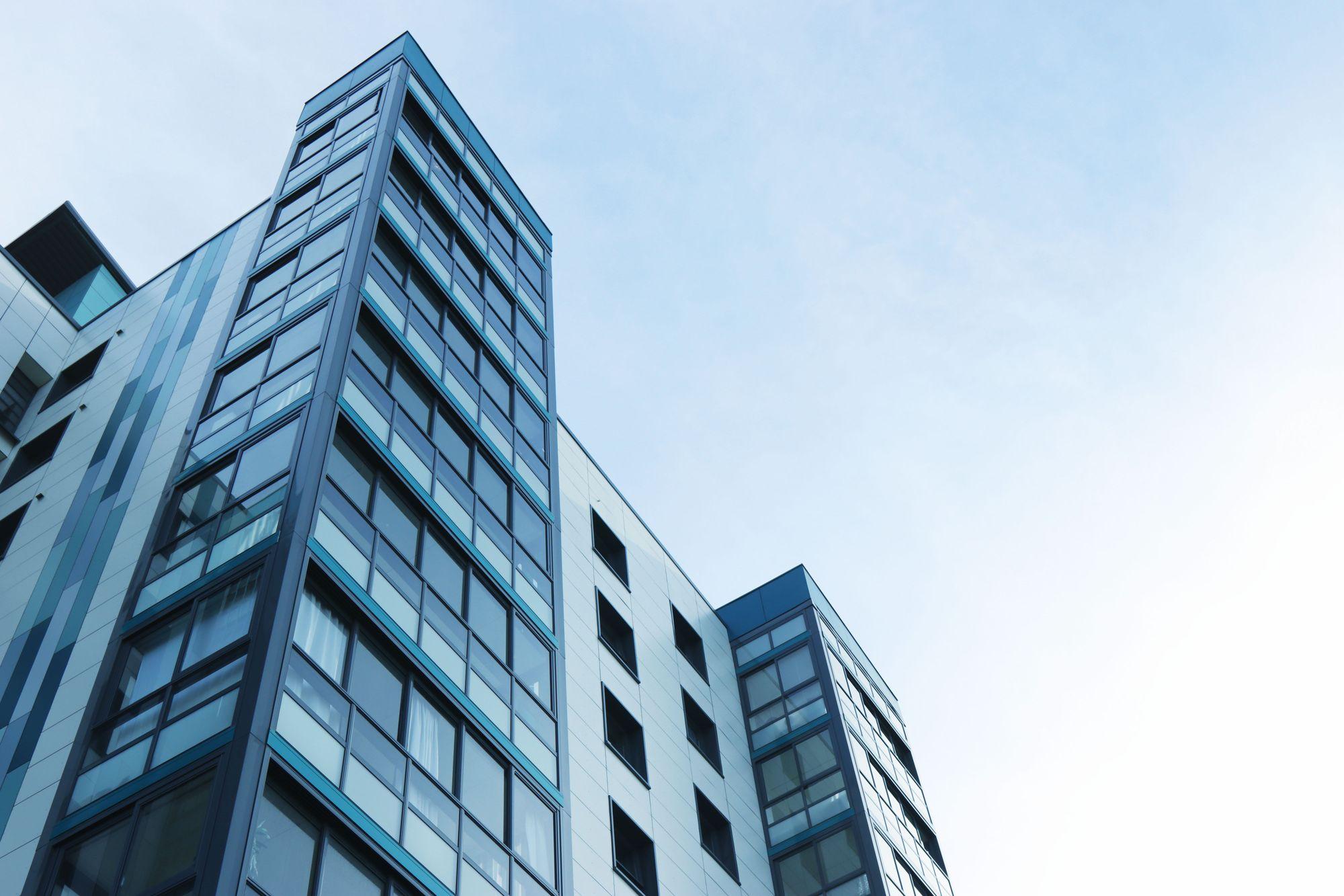 Modern multi-storey condominium building exterior against a clear sky, illustrating shared building costs that drive Ontario condo fees