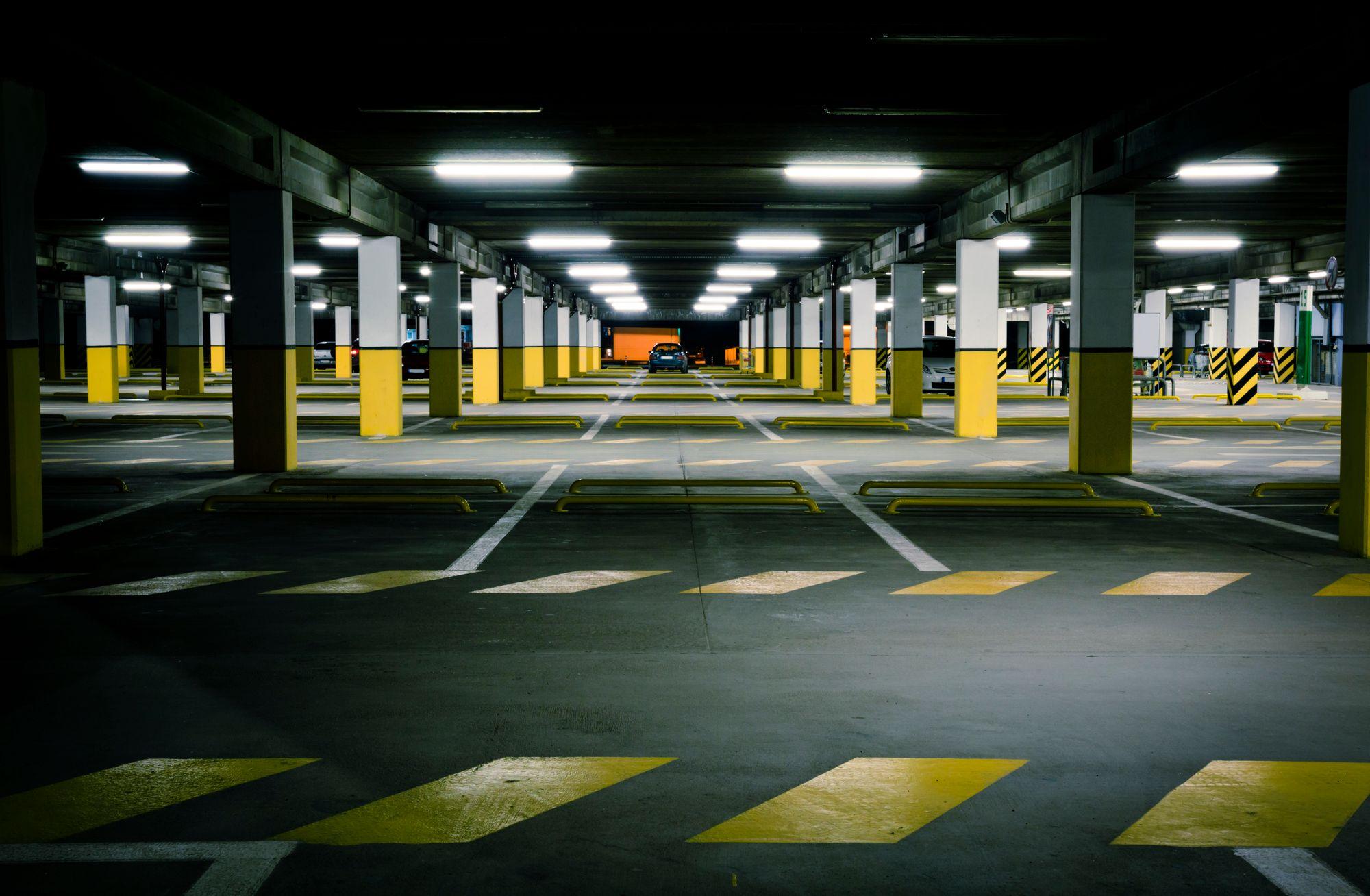 Underground parking garage in a residential condominium building, with marked parking spaces and painted support columns