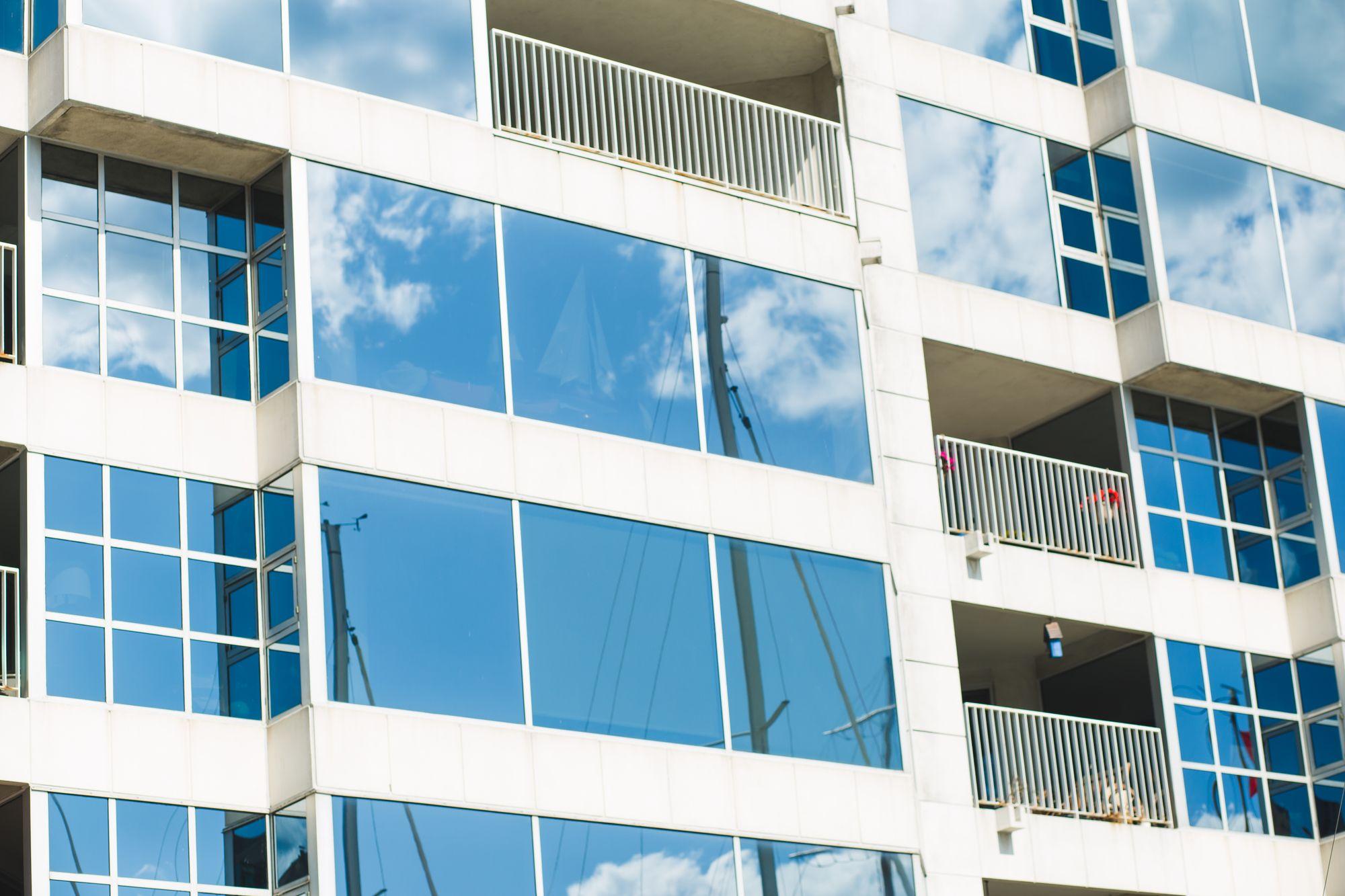 Stacked balconies and glass windows on a white Toronto condominium tower, where smoke can drift between neighbouring suites