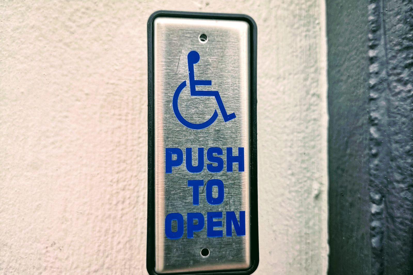 Accessible push-to-open door button at a building entrance, part of AODA compliance for condo common elements
